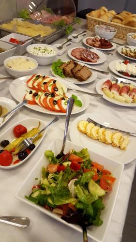 a table with many plates of food on it at Hotel Sokołowska Airport Modlin in Nowy Dwór Mazowiecki