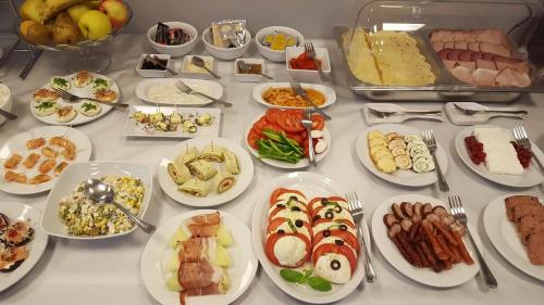 a table with many plates of food on it at Hotel Sokołowska Airport Modlin in Nowy Dwór Mazowiecki