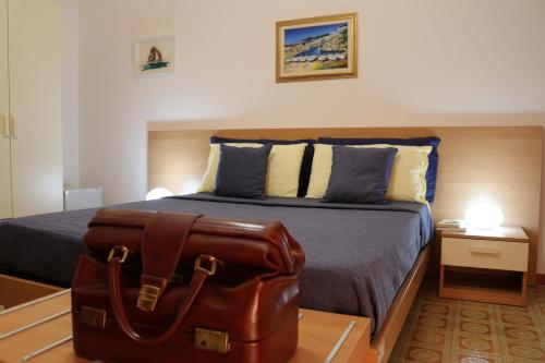 una valigia seduta su un letto in una camera da letto di Casa Noemi b&b a Uggiano la Chiesa
