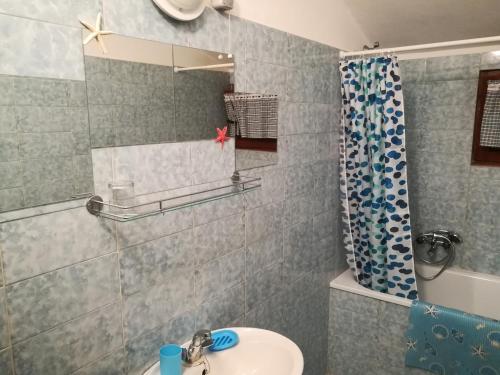 een badkamer met een wastafel en een spiegel bij Apartments Stjepic in Sukošan