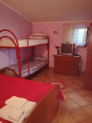 a room with two bunk beds and a television at Villa Rosa Maria in Villaggio Mosè