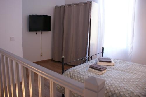 ヴィルヌーヴ・レ・ザヴィニョンにあるDuplex des Récolletsのベッドルーム1室(ベッド1台、壁掛けテレビ付)