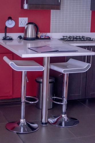 a kitchen with a counter with two stools at 314 on Clark Guest House in Pretoria