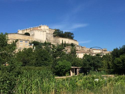 a large building on top of a hill at La vie de chateau in Grignan