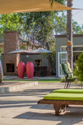 a patio with two chairs and a table with an umbrella at 314 on Clark Guest House in Pretoria