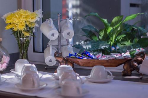 a table with dishes and a bowl on a table with flowers at 314 on Clark Guest House in Pretoria