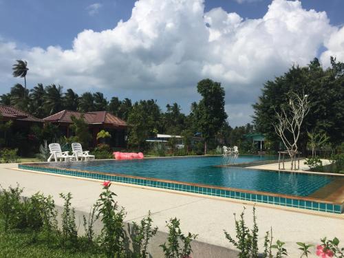 a large swimming pool with chairs and chairs in a yard at Saree Lagoon Villa Koh Samui in Lipa Noi