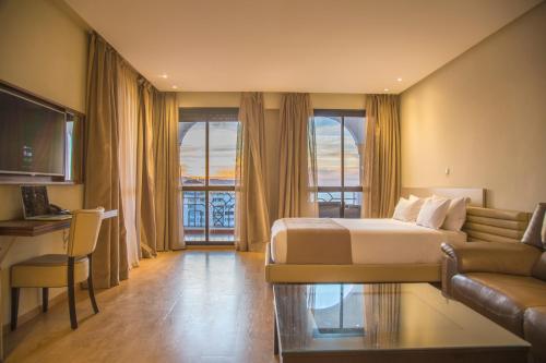 Le Rio Appart-Hotel City Center في طنجة: غرفه فندقيه بسرير واريكه