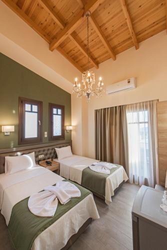 a hotel room with two beds and a chandelier at Konaki Ouranoupolis in Ouranoupoli