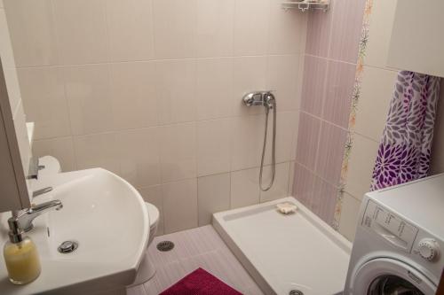 a bathroom with a toilet and a sink and a washing machine at Sea and Sun in Amoudara Herakliou