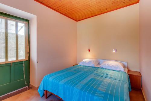 a bedroom with a blue bed with a green door at Apartments Josip & Maria in Veli Lošinj