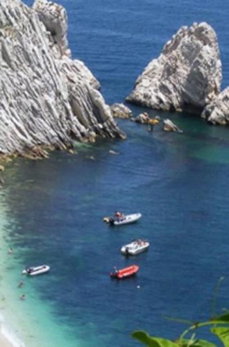 a group of boats in a body of water with rocks at La Casa di Isabella Loreto in Loreto