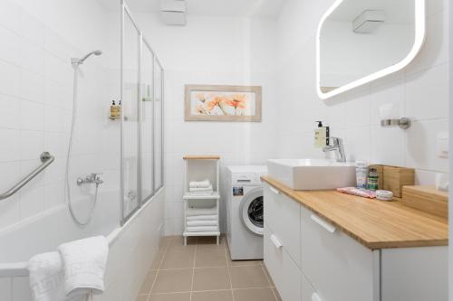 a white bathroom with a sink and a washing machine at Mar Suite Apartments - Simmering in Vienna