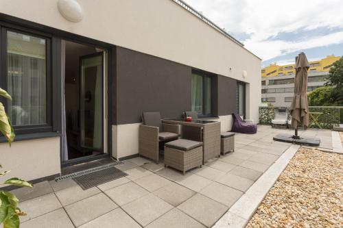 a patio with chairs and an umbrella on a building at Mar Suite Apartments - Simmering in Vienna