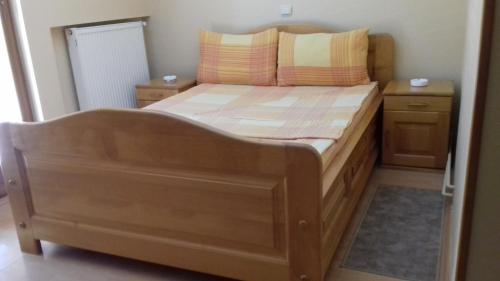 a bedroom with a wooden bed with two night stands at B&B Boem in Požarevac