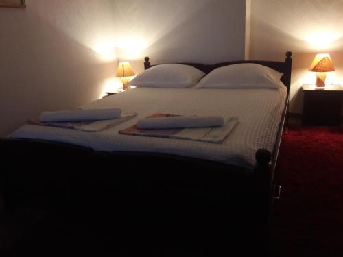 a bedroom with a large bed with white sheets and pillows at Apartment Kravica in Ljubuški