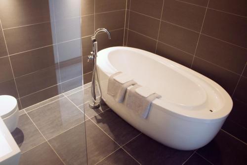 a bath tub in a bathroom with a faucet at B&B Landgoed Bergerven in Horn