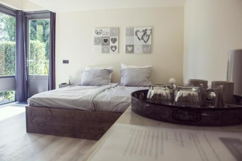 a bedroom with a large bed and a large window at B&B Landgoed Bergerven in Horn