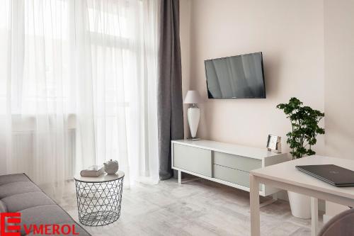 uma sala de estar com um sofá e uma televisão na parede em Evmerol Apartment (Hallera) em Breslávia