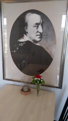 a picture of a man on a table with a vase with flowers at Polhem Bed & Breakfast in Falun