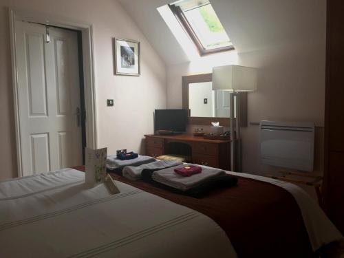 a bedroom with a bed and a desk with a mirror at The Lyn Valley Guest House in Lynmouth