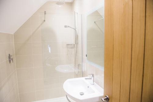 a bathroom with a shower and a toilet and a sink at Rutland Water Courtyard Rooms in Oakham