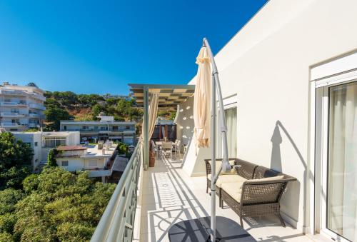 a balcony with chairs and an umbrella on a building at Sea and the city in Rhodes Town