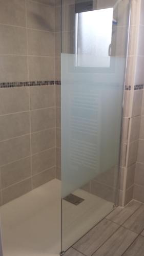 a shower with a glass door in a bathroom at Le Chalet de l'Authie in Saulchoy