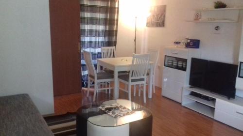 a living room with a table and chairs and a television at House Mihaela&nina in Seliste Dreznicko