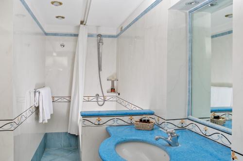 a bathroom with a blue sink and a mirror at Hotel Bellavista in Anacapri
