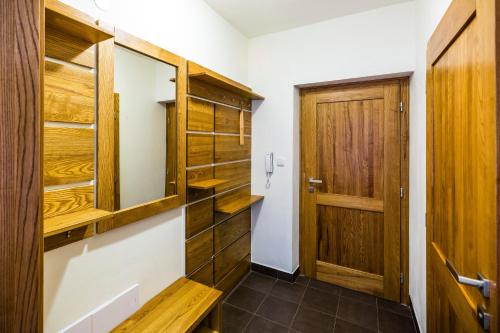 a walk in closet with wooden cabinets and a door at Penzion U Barana in Trojanovice