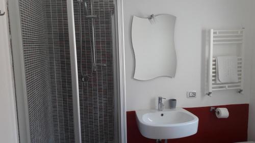 a white bathroom with a sink and a shower at House Il Conte in Palermo