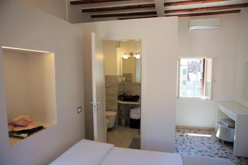 a bedroom with a bed and a bathroom at Ca' Zuliani Rooms in Chioggia