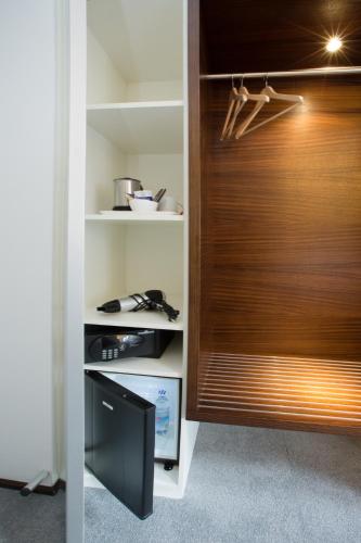 a closet with a wooden door and a television at Stern am Rathaus in Cologne