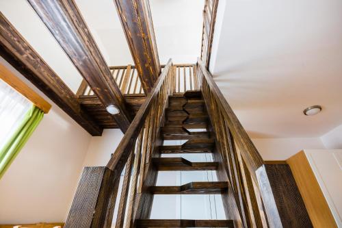 a winding staircase in a house with wooden ceilings at Penzion U Barana in Trojanovice