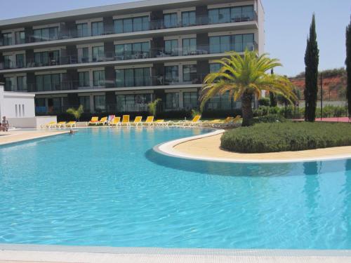 a large swimming pool in front of a building at Golf Residence Apartment in Vilamoura