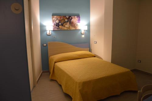 Dormitorio pequeño con cama con manta amarilla en Good Night Moon B&B, en Crotone