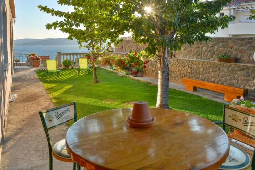 a wooden table and chairs with a view of the ocean at Apartments Dada in Senj