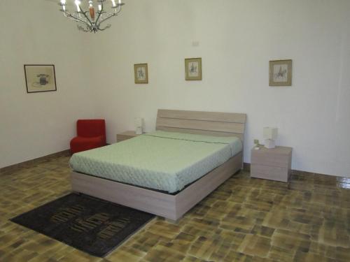una camera con letto e sedia rossa di Appartamento Vacanza Luna a Partinico