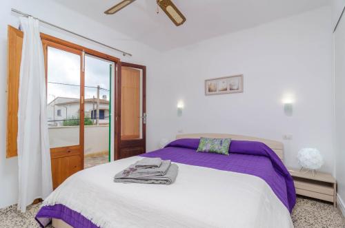 - une chambre blanche avec un grand lit et une fenêtre dans l'établissement Casa Delfin, à Sa Ràpita