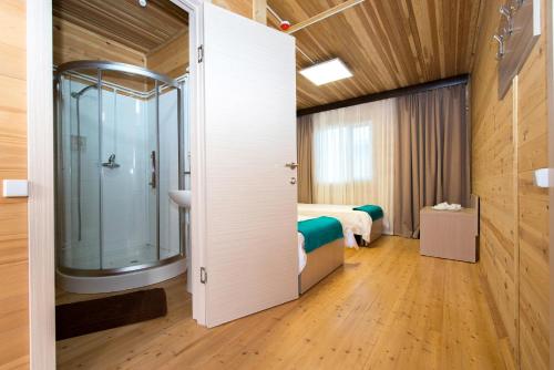 a bathroom with a shower and a bed in a room at Aquamarine Resort in Akshi