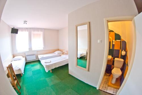 a large room with two beds and a mirror at Maraton in Lubenia