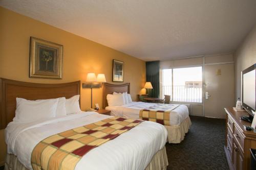 a hotel room with two beds and a window at Budget Inn Sanford International Airport in Sanford