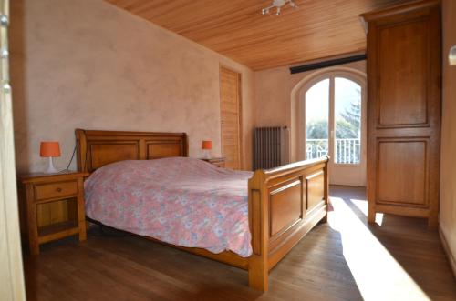 une chambre avec un lit et une grande fenêtre dans l'établissement Villa Le Gai Soleil, à Embrun