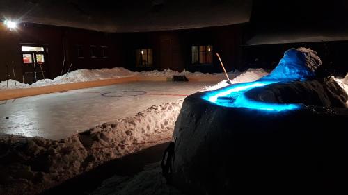an ice hockey rink with blue lights on it at Penzion Sileo in Pribylina