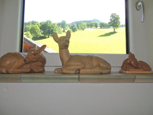 three wooden animals sitting on a shelf next to a window at Haus Bergfried in Filzmoos