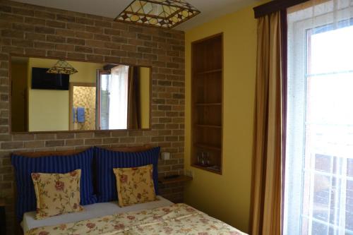 a bedroom with a bed with a blue headboard and a mirror at Penzion Aurooms in Zlatníky