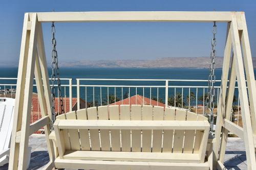 a swing on a balcony with a view of the ocean at אחוזת חוף כנרת kinneret village in Tiberias