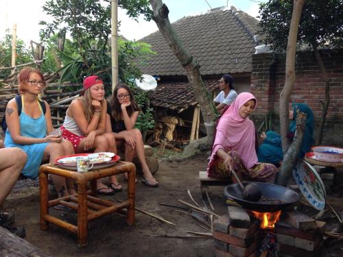 a group of women sitting in front of a fire at Mu Homestay in Tetebatu