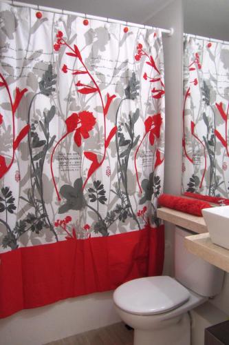 a bathroom with a red and white shower curtain at La Choza VIP Roja in Coquimbo